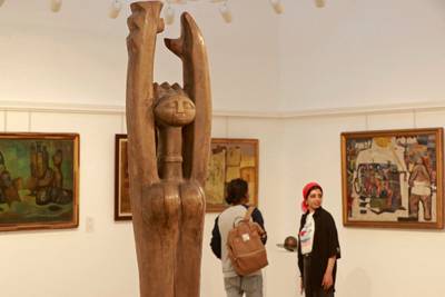 The 'maternal statue', a work by Iraqi artist Jawad Selim, that was rediscovered in a district known for its antiques and second-hand goods shops is on display. The painting on the right is by Shakir Hassan Al Said. 