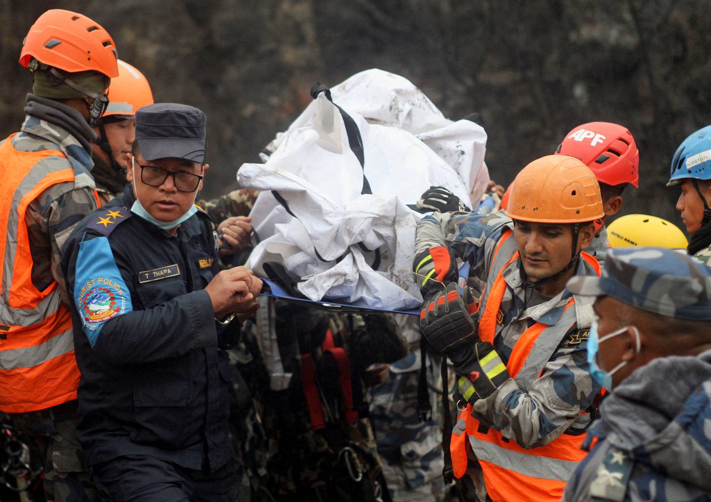 Rescuers recover the body of a victim from the site of the plane crash.  Reuters