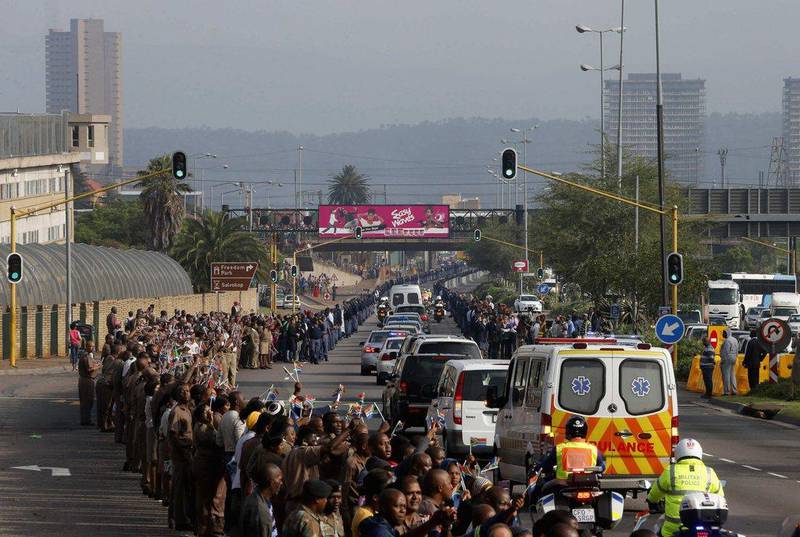 Prison wardens and members of the public watch as the procession carrying the coffin of former President Nelson Mandela. Mike Hutchings / Reuters