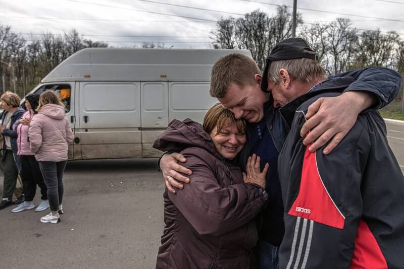 Oleksandr, 25, meets his parents Olga, 49, and Oleksandr, 50, who fled from the Russian-occupied village of Lyubimivka, at the evacuation point in Zaporizhzhia. EPA