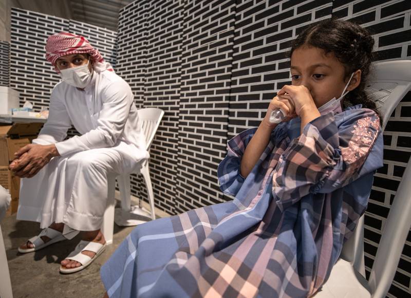 Parents take their children to Biogenix Labs in Masdar City to take PCR or saliva tests. Pupils will need to show a negative nasal PCR or saliva test result taken within 96 hours before they can return to in-person classes on Sunday. Victor Besa/The National