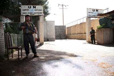 Afghan security officials stand guard outside the UN office in Herat.