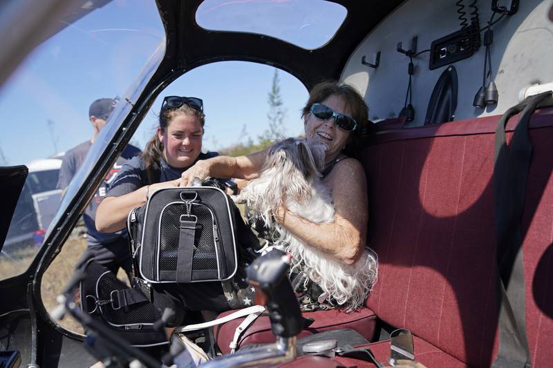 Helen Koch, a dog breeder, is evacuated with some of her 17 pets on a helicopter. AP