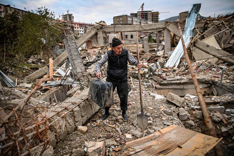 Retired police officer Genadiy Avanesyan, 73, searches for belongings in the remains of his house, which is said was destroyed by Azeri shelling, in the city of Stepanaker.  AFP