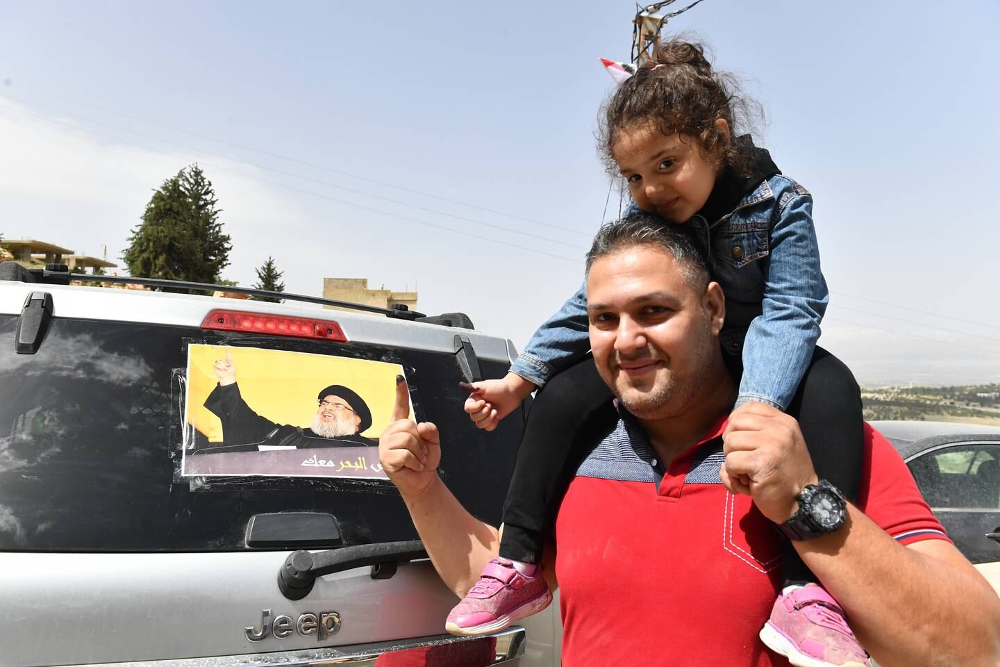 A voter next to a picture of Hezbollah leader Hassan Nasrallah during parliamentary elections at a polling station in Bekaa valley, Lebanon, on May 15. EPA 