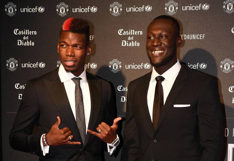 Manchester United's French midfielder Paul Pogba (L) and British grime and hip hop artist Stormzy pose on the red carpet as they arrive to attend the "United for UNICEF Gala Dinner" at Old Trafford in Manchester, north-west England, on November 15, 2017. (Photo by Paul ELLIS / AFP)