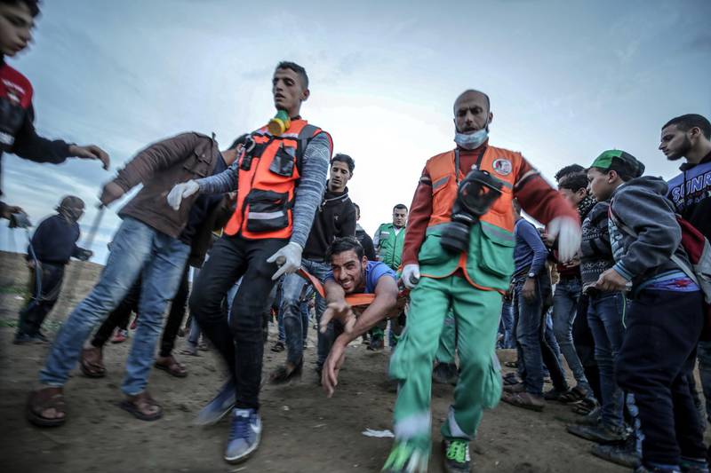 epa07185337 Palestinian medics carry a wounded youth during clashes after Friday protests near the border between Israel and Gaza Strip in the east Gaza Strip, 23 November 2018. Protesters call for the right of Palestinian refugees across the Middle East to return to homes they fled in the war surrounding the 1948 creation of Israel.  EPA/MOHAMMED SABER