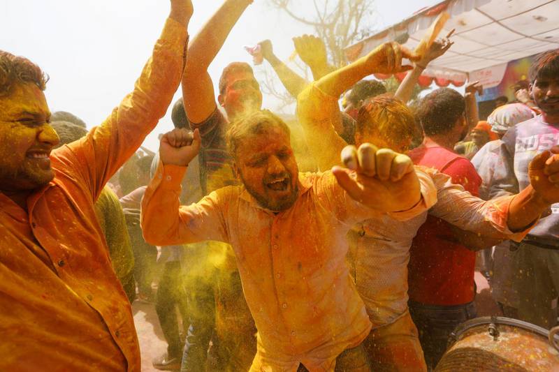 People dance as coloured powder is thrown during Lathmar Holi celebrations, amidst the spread of the coronavirus disease (COVID-19), in the town of Barsana, northern state of Uttar Pradesh, India, March 23, 2021. REUTERS/Adnan Abidi