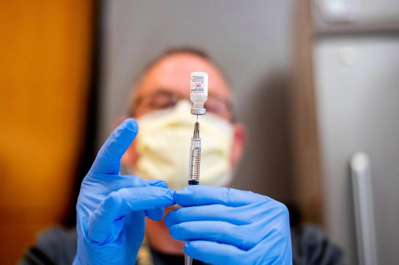 A pharmacist draws saline while preparing a dose of Pfizer's Covid-19 vaccine in Sacramento, California. AP Photo