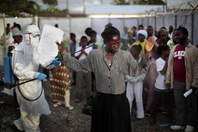 A woman being discharged from the Island Clinic Ebola treatment centre in Monrovia is being sprayed with disinfectant before she leaves the facilities.