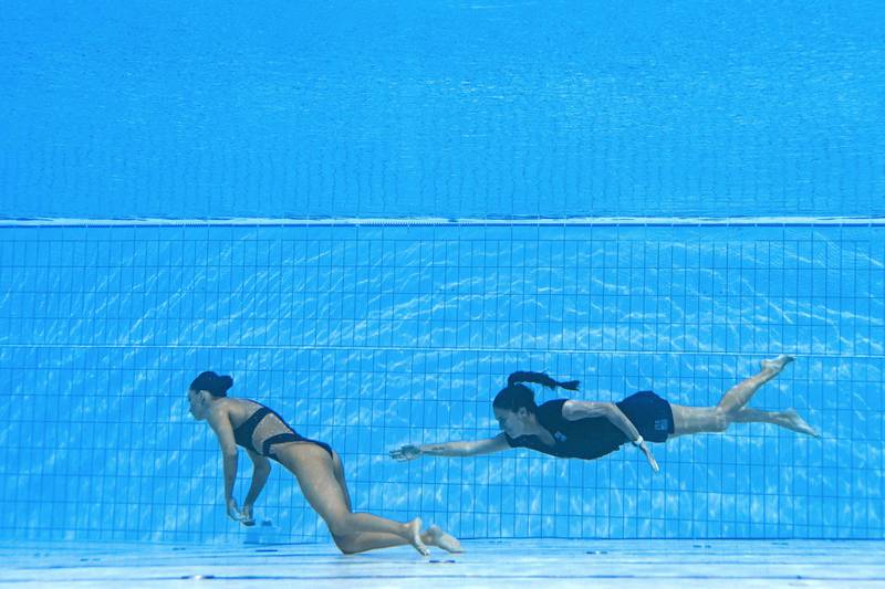 A member of Team USA (R) swims to recover USA's Anita Alvarez (L), from the bottom of the pool during an incendent in the women's solo free artistic swimming finals, during the Budapest 2022 World Aquatics Championships at the Alfred Hajos Swimming Complex in Budapest on June 22, 2022.  (Photo by Oli SCARFF  /  AFP)