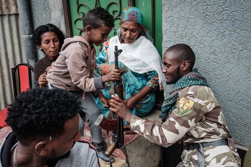 A soldier of Tigray Defence Force (TDF) hands his rifle to his four-year-old son in Mekelle.