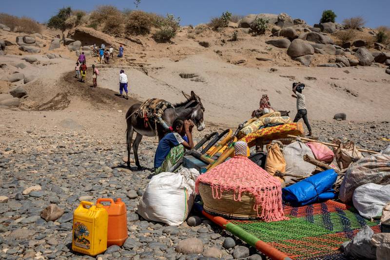 Tigray refugees who fled the conflict in the Ethiopia's Tigray arrive with their furniture and donkey on the banks of the Tekeze River on the Sudan-Ethiopia border, in Hamdayet, eastern Sudan. AP Photo