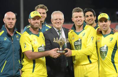Australia Prime Minister Scott Morrison hands the winners' trophy to the the hosts after their one-wicket triumph in the T20 warm-up match against the Sri Lankans in Canberra. Getty Images