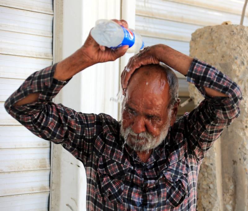 A man uses cold water to cool himself down. EPA