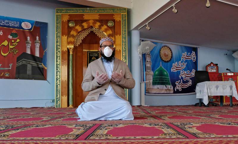 Imam Farouk Mohamed, wearing a protective mask, prays on the first day of Ramadan in the mosque of Brescia, Italy, 24 April, 2020. EPA