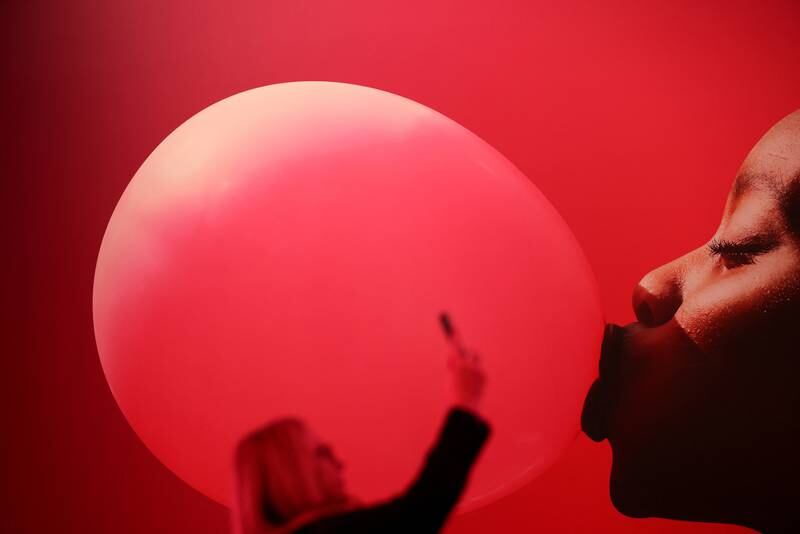 A woman holds up an electronic device during the GSMA's 2023 Mobile World Congress in Barcelona, Spain. Reuters