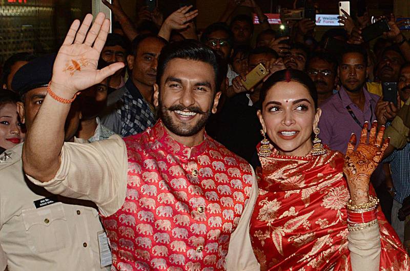 Bollywood actors and recently-wedded couple Ranveer Singh (L) and Deepika Padukone acknowledge fans gathered at the Mumbai international airport early on November 18, 2018, following their return from their nuptials at Italy's Lake Como.  Photo / AFP