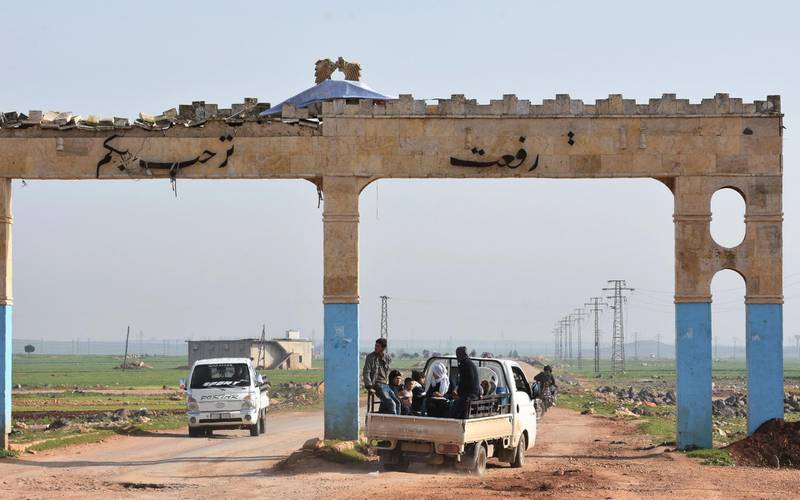Civilians fleeing the city of Afrin in northern Syria are seen on the back of a pick up truck as they enter the village of Tal Rifaat in the government-controlled part of the northern Aleppo province, on March 18, 2018. George Ourfalian / AFP