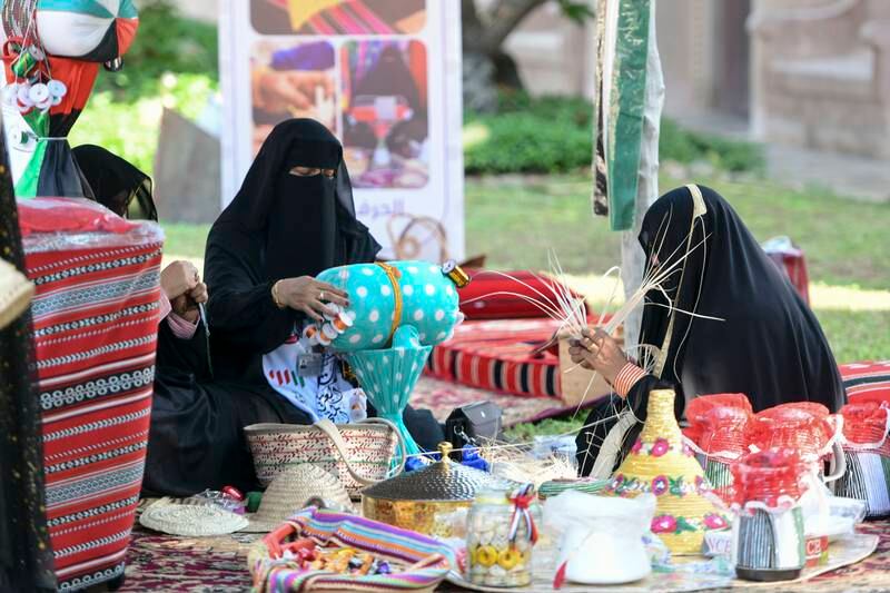 Emirati women make traditional handicrafts at the Heritage Village, in Abu Dhabi. Khushnum Bhandari / The National

