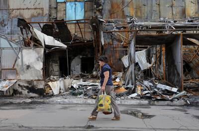 A woman walks past a destroyed market near a railway station in Donetsk. Reuters 
