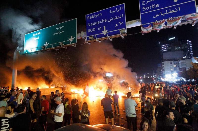 Protesters burn tyres on the highway in the Antelias area north of Beirut after a further drop in the unofficial exchange rate of the Lebanese pound triggered fresh anti-government demonstrations on June 11, 2020.  EPA