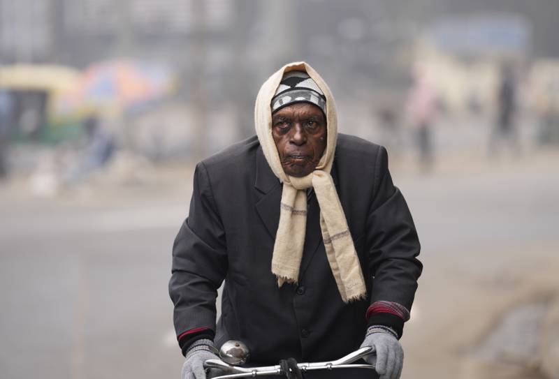 A cyclist wraps up warm on a cold day. AP