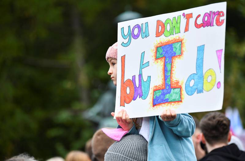 A child holds a placard with the slogan 'you don't care but I do!'. Reuters
