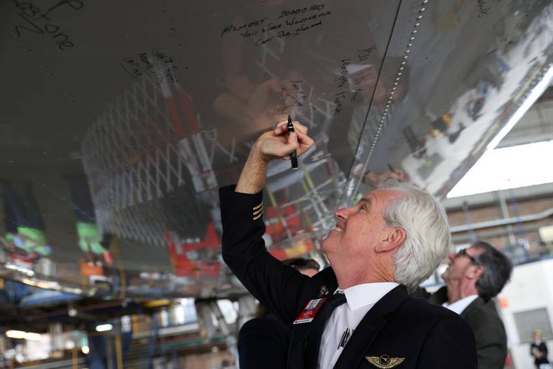 A Qantas pilot writes a message on the bottom of a Qantas 747 jumbo jet, before its last departure from the Sydney Airport. Reuters