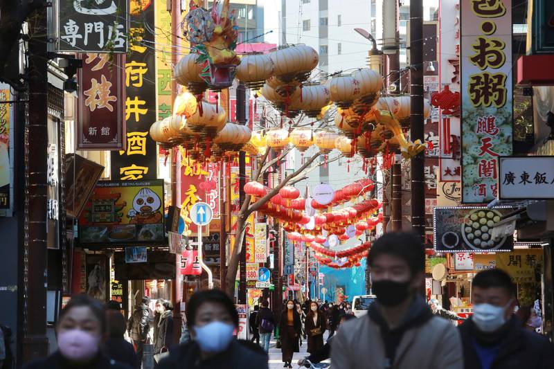 People wearing face masks to protect against the spread of the coronavirus walk through China Town in Yokohama, Kanagawa prefecture, near Tokyo. AP