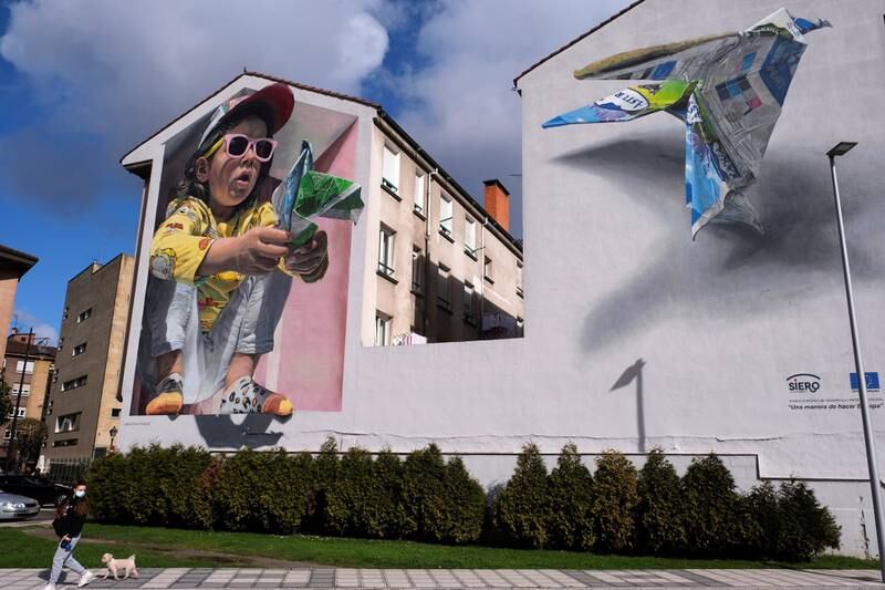 A mural depicting a little girl making origami, made by Spanish artist David Esteban and aimed at denouncing consumerism, decorates a building in Lugones, Spain. EPA