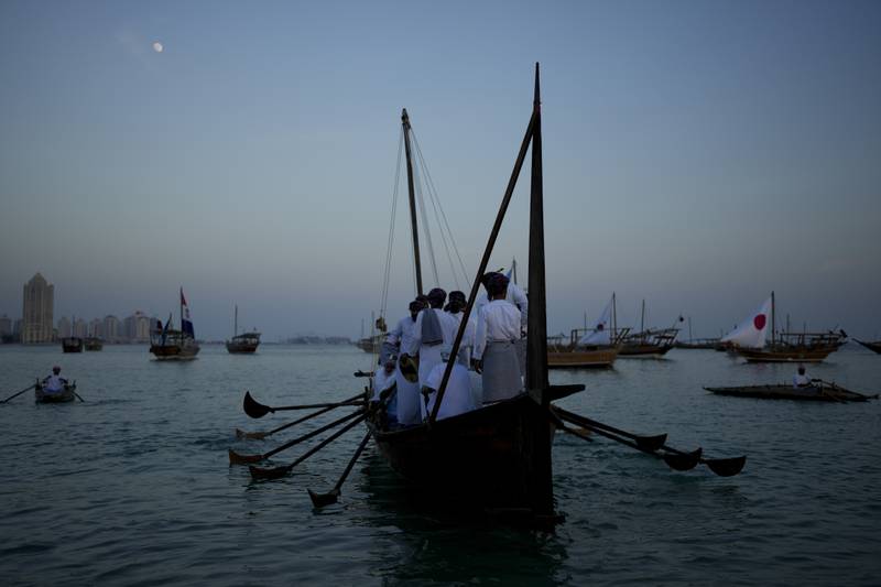 Men stand on a boat at Katara Beach in Doha. AP