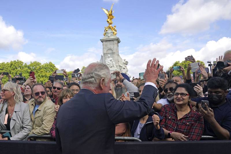 King Charles greets members of the public as he walks by the gates of Buckingham Palace after the death of Queen Elizabeth. AP