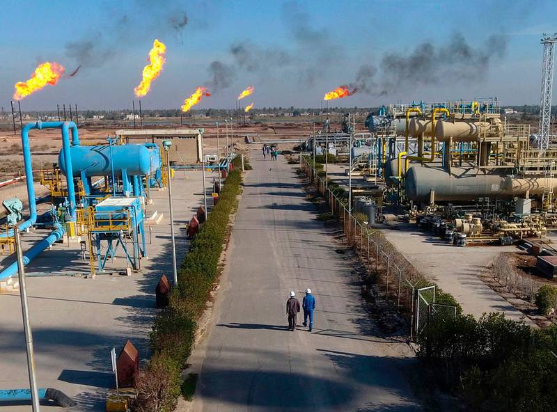FILE - in this Thursday, Jan. 12, 2017 file photo, laborers walk in the Nihran Bin Omar field north near Basra, Iraq. Prime Minister Adel Abdul-Mahdi said Tuesday, May 7, 2019 that he has instructed Iraq's Oil Ministry to finalize an agreement with global energy giants ExxonMobil and PetroChina to lead a $53 billion megaproject to boost oil production. (AP Photo/Nabil al-Jurani, File)