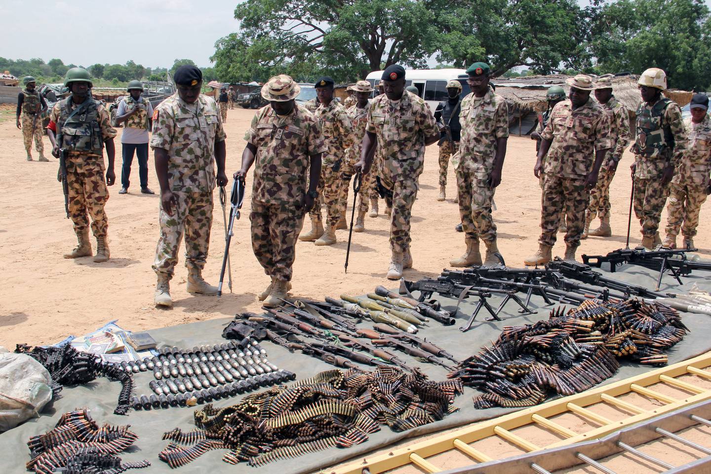 Military commanders inspect arms and ammunitions recovered from Boko Haram militants in Nigeria. (Photo by AUDU MARTE / AFP)
