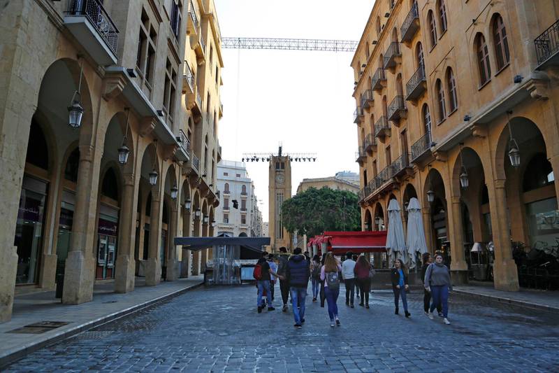 Pedestrians walk on a street leading to Parliament square in Beirut after security forces removed roadblocks and barbed wire barriers. Husein Malla / AP Photo