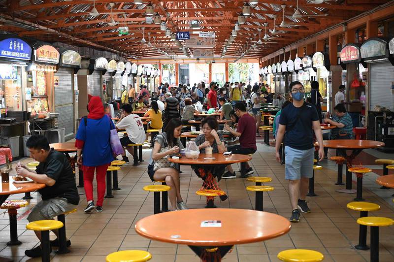People have their lunch at the Maxwell market hawker centre in Singapore on December 17, 2020, a day after Singapore's street food culture was included on the Unesco list. AFP