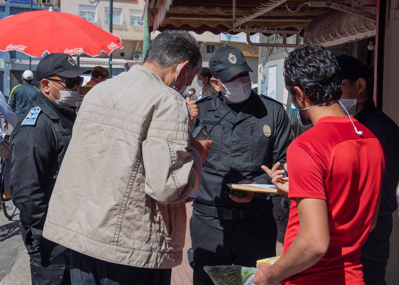 A Moroccan police officer confronts  curfew violators in Rabat. EPA