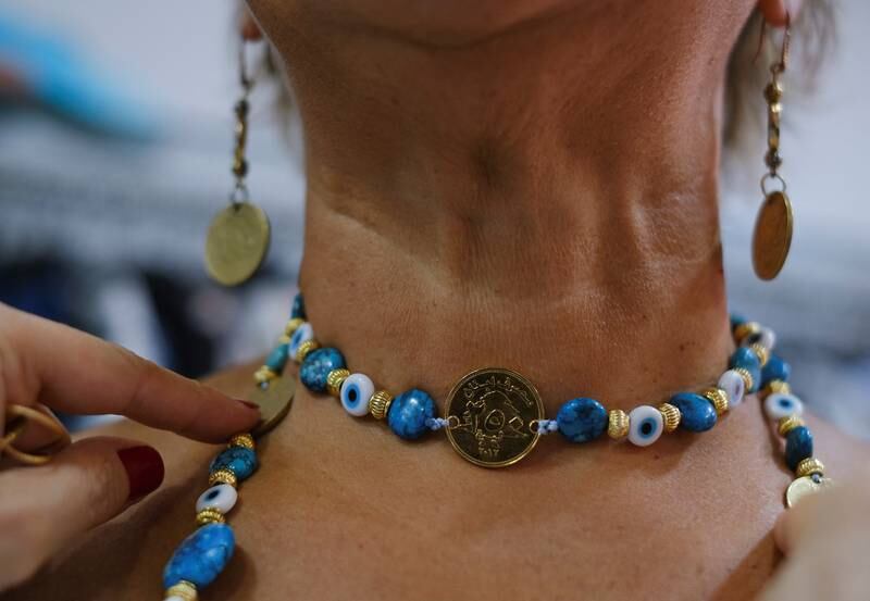 Rima Mawlawi El Samad wears a necklace and earrings at her shop.