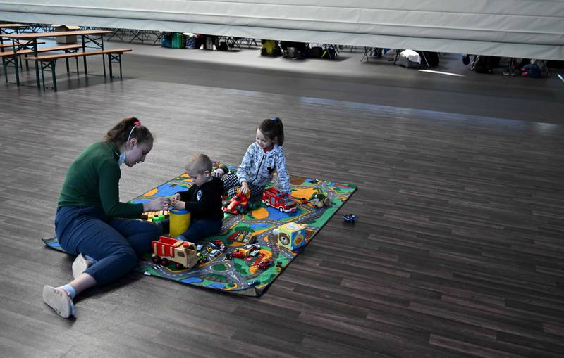 Ukrainian refugees play on the floor in the sports hall. AFP