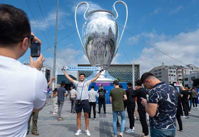 A Manchester City fan holds a banner in front of an inflatable replica of the Uefa Champions League trophy in Taksim Square in Istanbul on the eve of the Champions League final match between Inter Milan and Manchester City at Istanbul's Ataturk Olympic Stadium. AFP