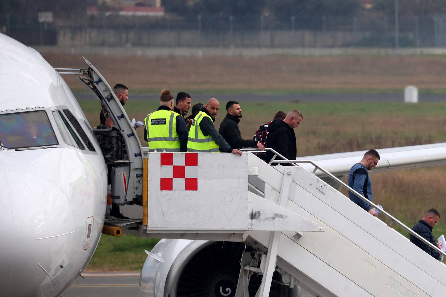 Britische Einwanderungsbeamte in einem Flugzeug mit aus England deportierten Einwanderern kommen in Tirana an.  Reuters