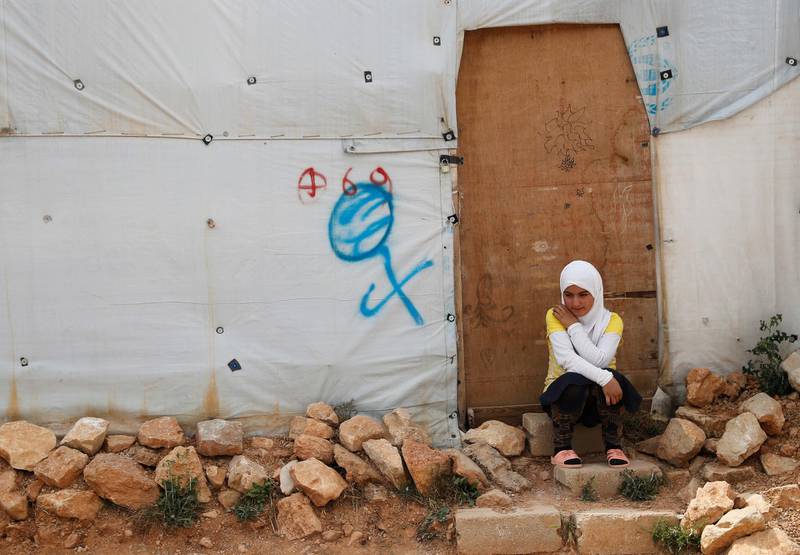 A Syrian refugee girl sits outside her tent, at an informal refugee camp, in Arsal, near the border with Syria, east Lebanon, Wednesday, June 13, 2018. A public spat between the Lebanese government and the United Nation's refugee agency deepened Wednesday as Lebanon's caretaker foreign minister kept up his criticism, accusing the agency of discouraging Syrian refugees from returning home. Lebanon is home to more than a million Syrian refugees, or about a quarter of the country's population, putting a huge strain on the economy. (AP Photo/Hussein Malla)