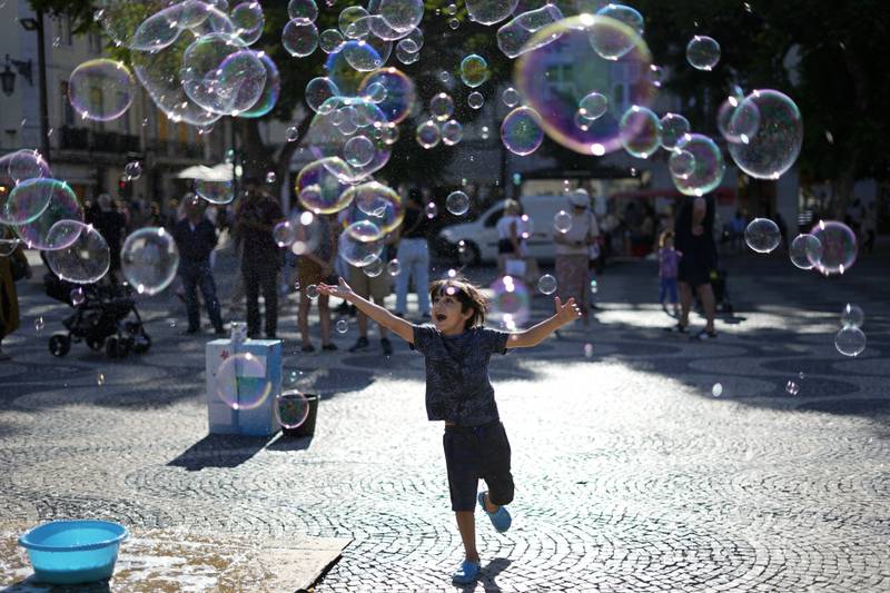 A child chasing soap bubbles made by a street artist in Lisbon's downtown Rossio Square. AP Photo