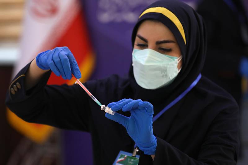 Medic Azin Chakeri prepares a Coviran Barekat Covid-19 vaccine to administer to volunteers during the third phase of the clinical trial of the Iranian developed vaccine, in a staged event at the Eram Grand Hotel in Tehran, Iran, Sunday, April 25, 2021. Shifa Pharmed is in the last stage of their vaccine study, while the country has been hardest-hit by the coronavirus in the Middle East. (AP Photo/Vahid Salemi)