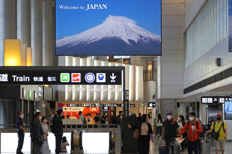 Visitors wearing face masks arrive at Narita international airport near Tokyo in June 2022. AP Photo / Shuji Kajiyama