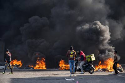 Iraqi protesters are pictured next to burning tyres during clashes with police during anti-government demonstrations in the city of Nasiriyah in the Dhi Qar province in southern Iraq.  AFP