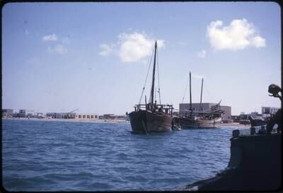 Abu Dhabi town 1963 Showing the beach front with two dhows anchored offshore. Development is just beginning. The building on the right hand side, behind the dhow is the Abu Dhabi branch of the British Bank of the Middle East (BBME) now part of the HSBC Group. Photo by David Riley