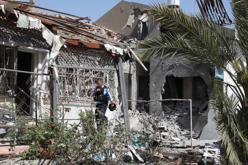 A member of Israeli security forces investigates the scene where a rocket fired from the Gaza Strip hit a house in the city of Ashdod. EPA