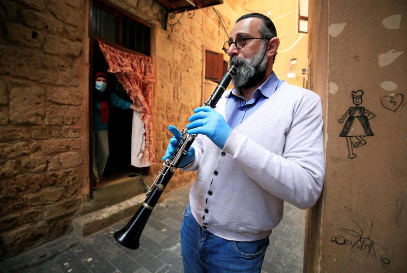 Tarek Bashasha, a 49 year-old artist, plays the clarinet to entertain people at their homes, during a countrywide lockdown in Sidon's old city, southern Lebanon. Reuters